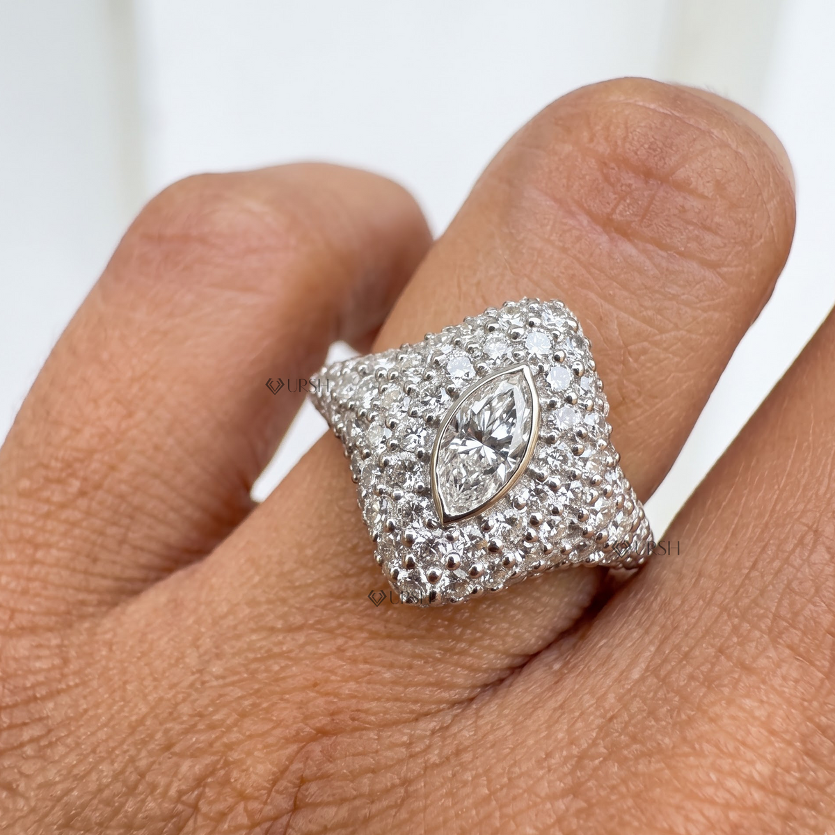 White gold pave diamond shield statement ring worn on pinky finger.