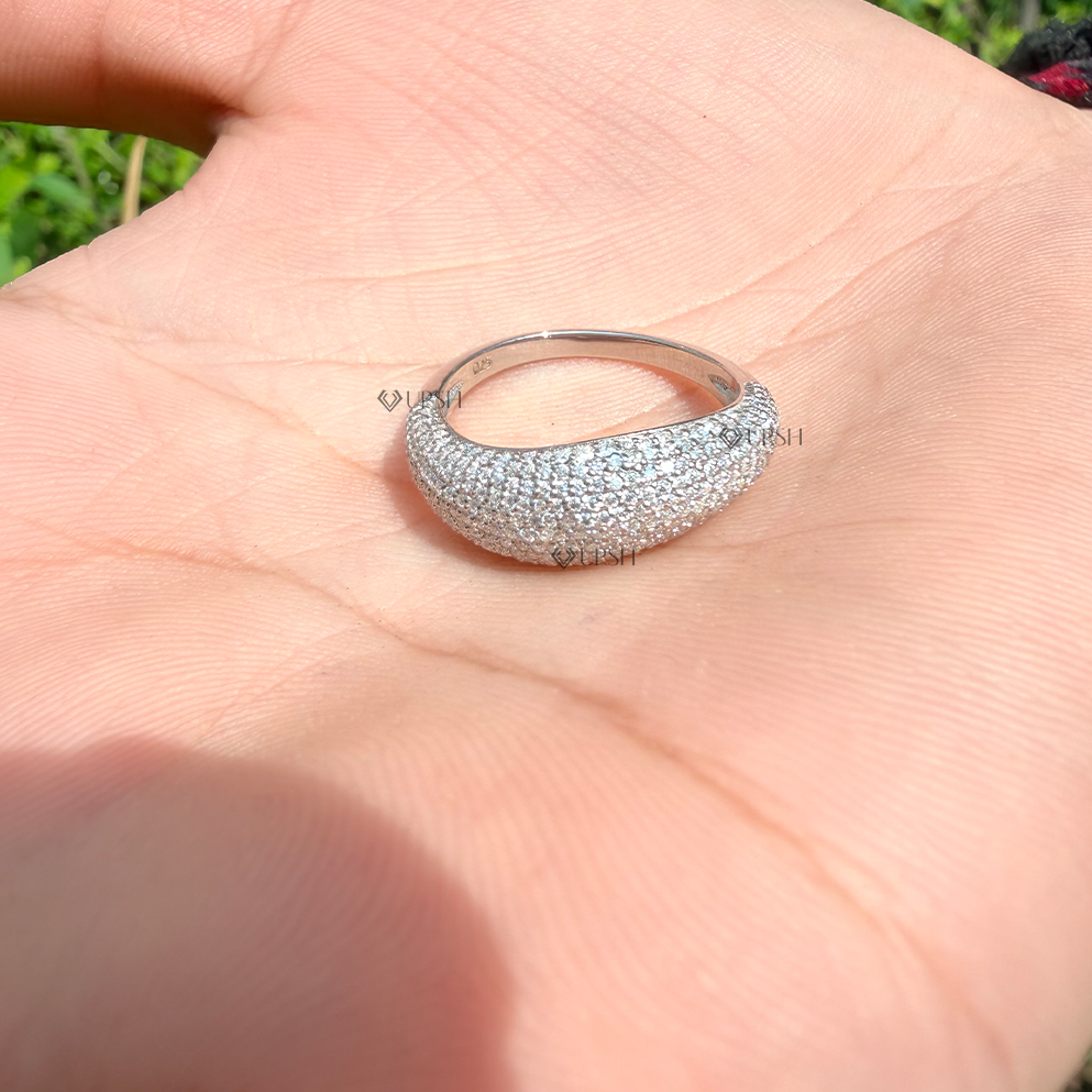 Holding solid white gold full pavé tapered dome ring on palm to display curved profile and scale