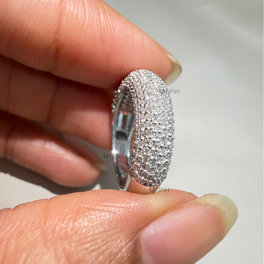 Detailed macro close-up holding solid gold full pavé dome ring to display micro-prong stone settings