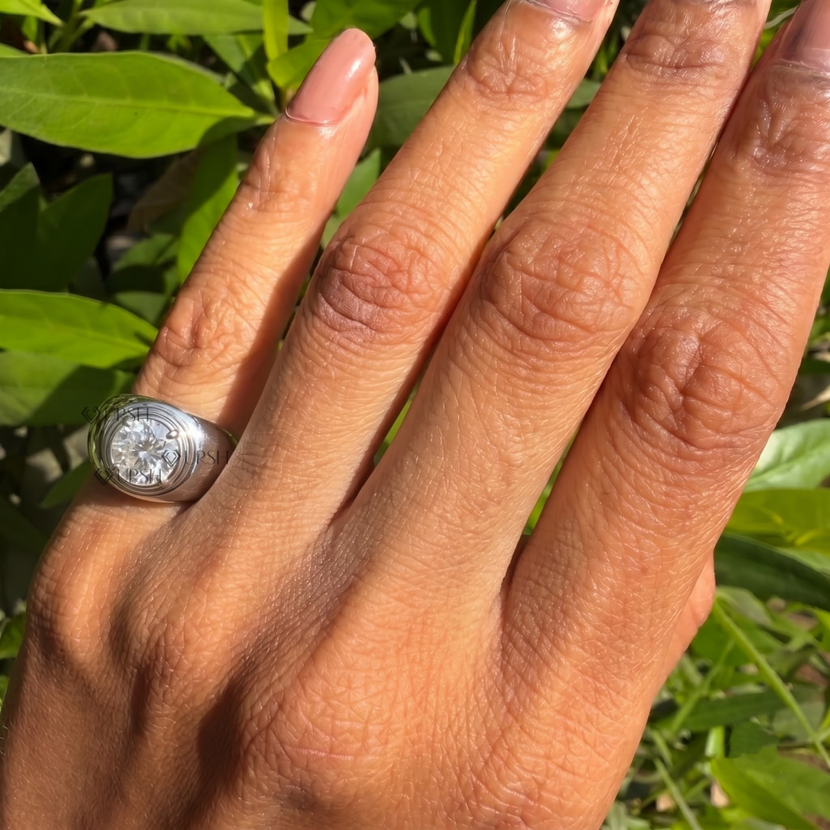 Chunky dome solitaire signet ring styled gracefully on finger in natural daylight