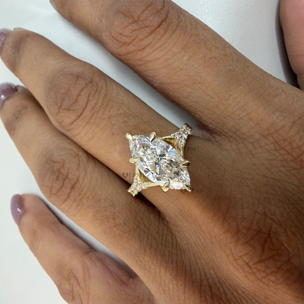 Marquise cut lab diamond ring with geometric diamond-set shoulders on manicured hand