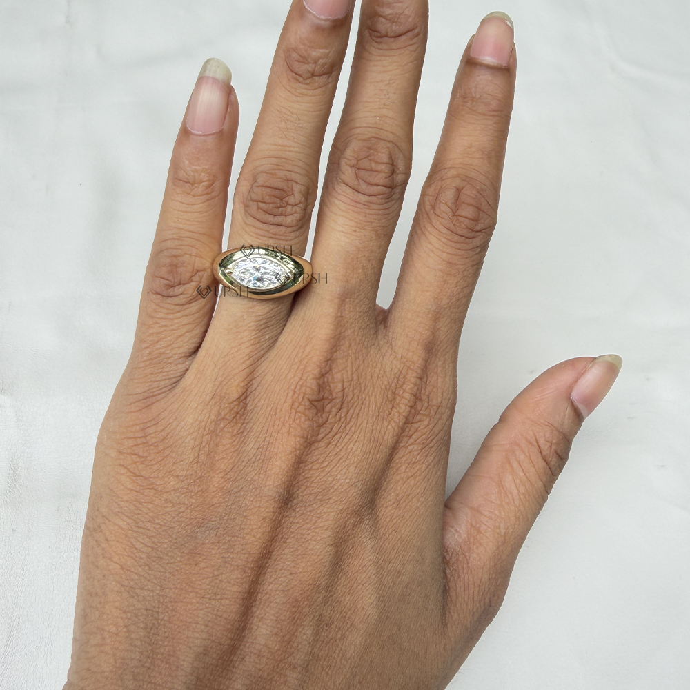 Brilliant sparkle of marquise lab grown diamond under natural lighting on polished yellow gold dome