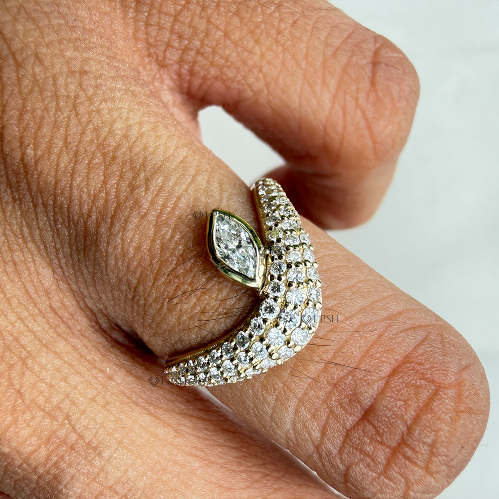 Detailed daylight close-up of asymmetrical marquise and pavé wave ring worn on hand