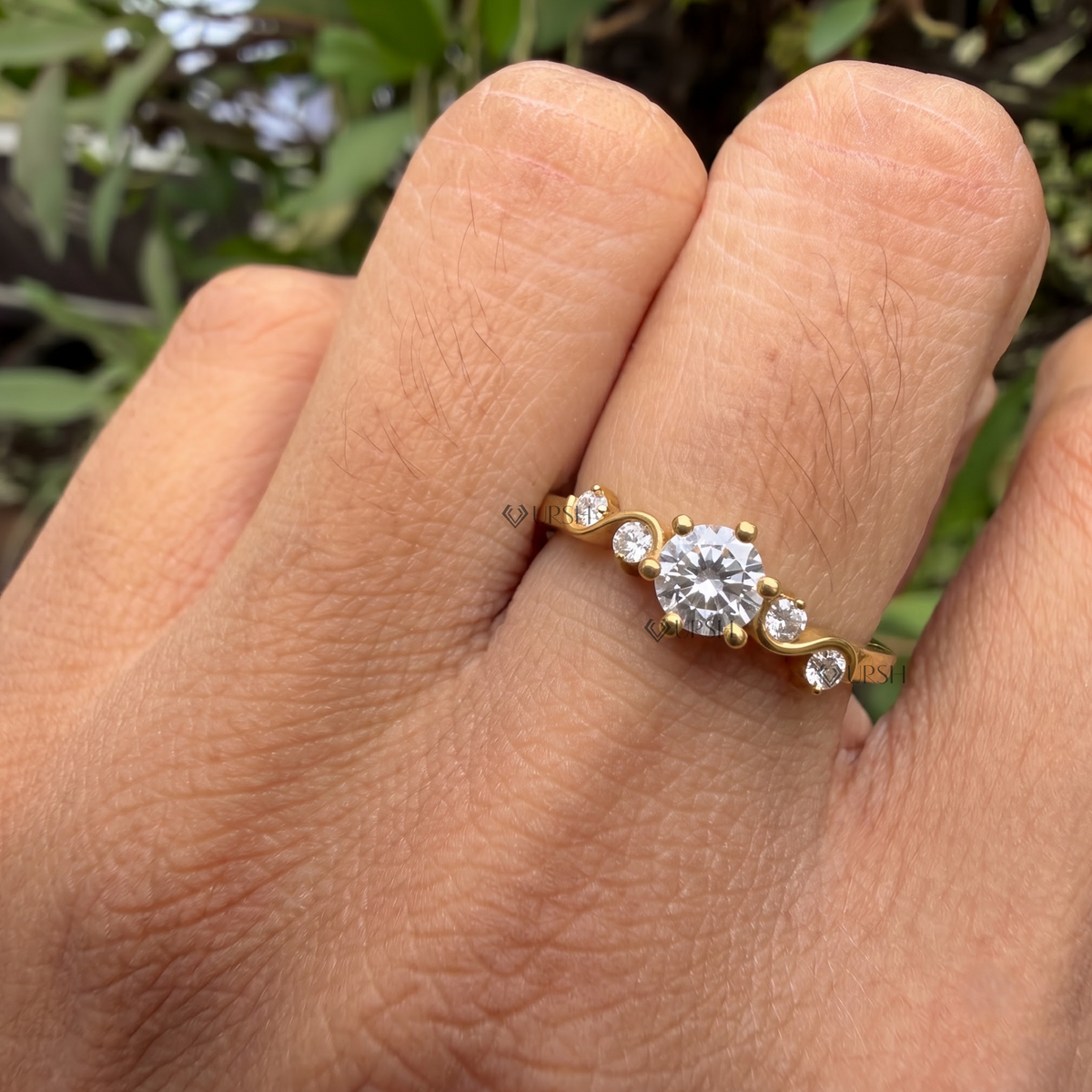 Asymmetrical wave diamond engagement ring styled gracefully on finger in natural daylight