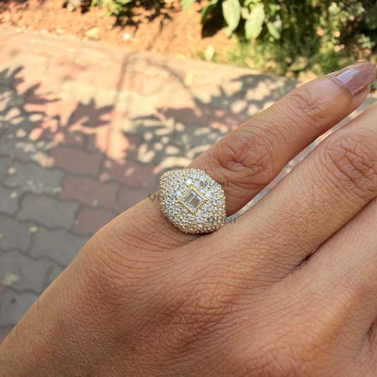 Yellow gold chunky diamond signet ring styled across finger under direct sun