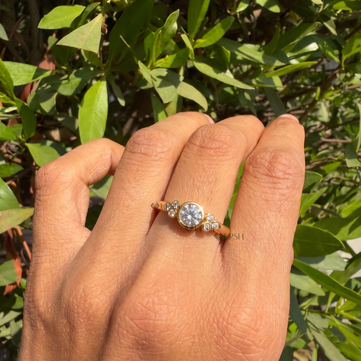 Bezel-set cluster diamond engagement ring styled gracefully on finger in natural daylight