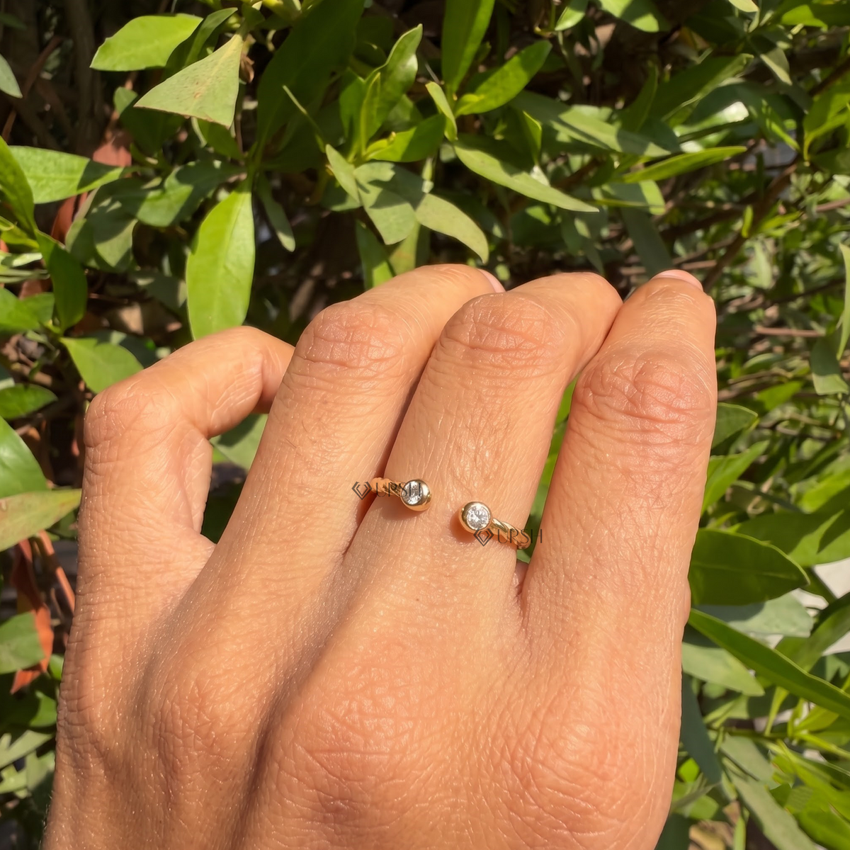 Daylight angle view of bezel-set open band worn on hand showcasing modern styling