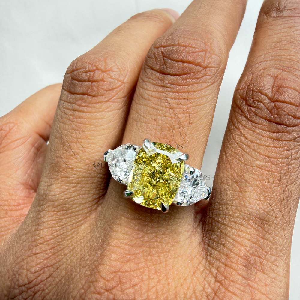 Stunning yellow cushion and heart diamond trilogy ring styled gracefully on hand in natural daylight