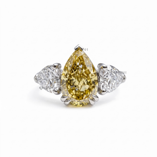 Solid two-tone gold three-stone engagement ring featuring a vivid canary yellow pear lab diamond flanked by matching pear side stones and a pavé band