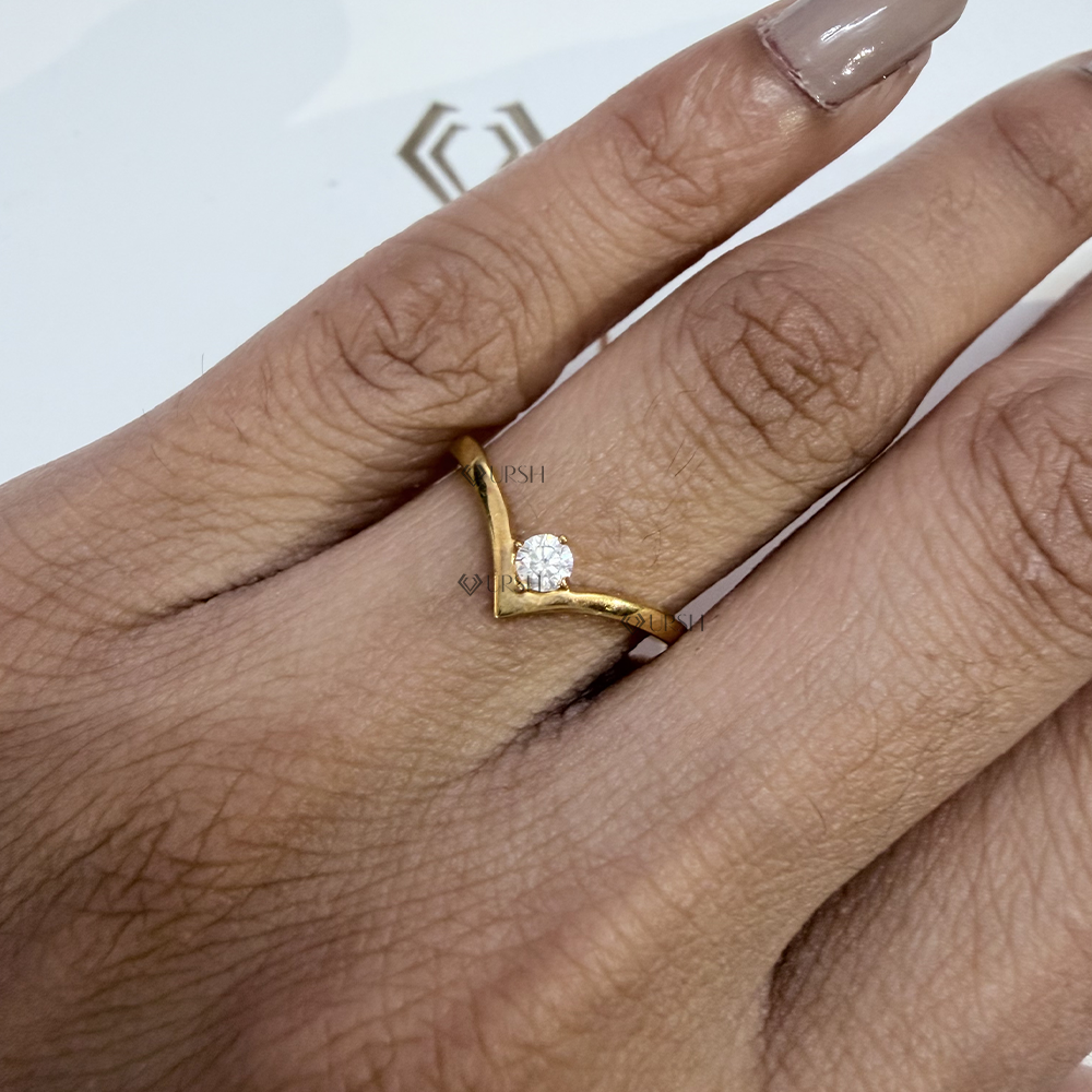 Dainty gold chevron contour wedding band worn on finger highlighting modern wishbone silhouette