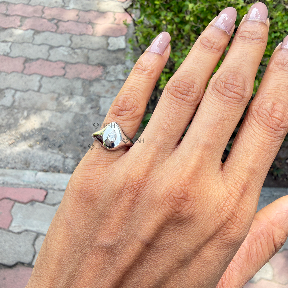 Chunky organic pear diamond dome ring styled on hand against outdoor background