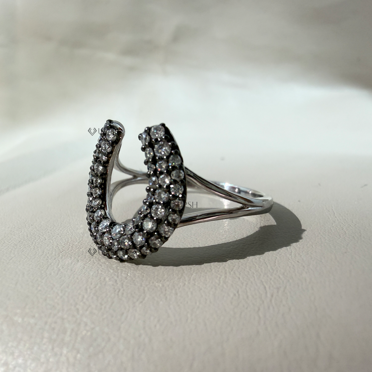 Solid white gold architectural horseshoe ring covered in brilliant round diamond pavé