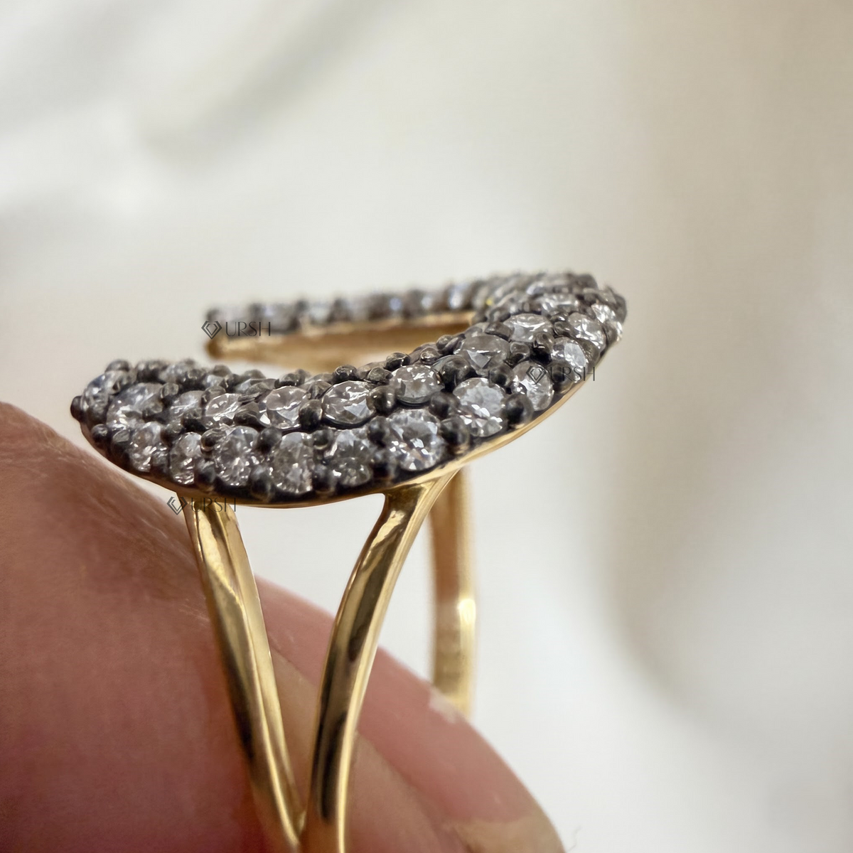 Side angle holding solid gold horseshoe ring displaying split-shank architecture and curved dome height