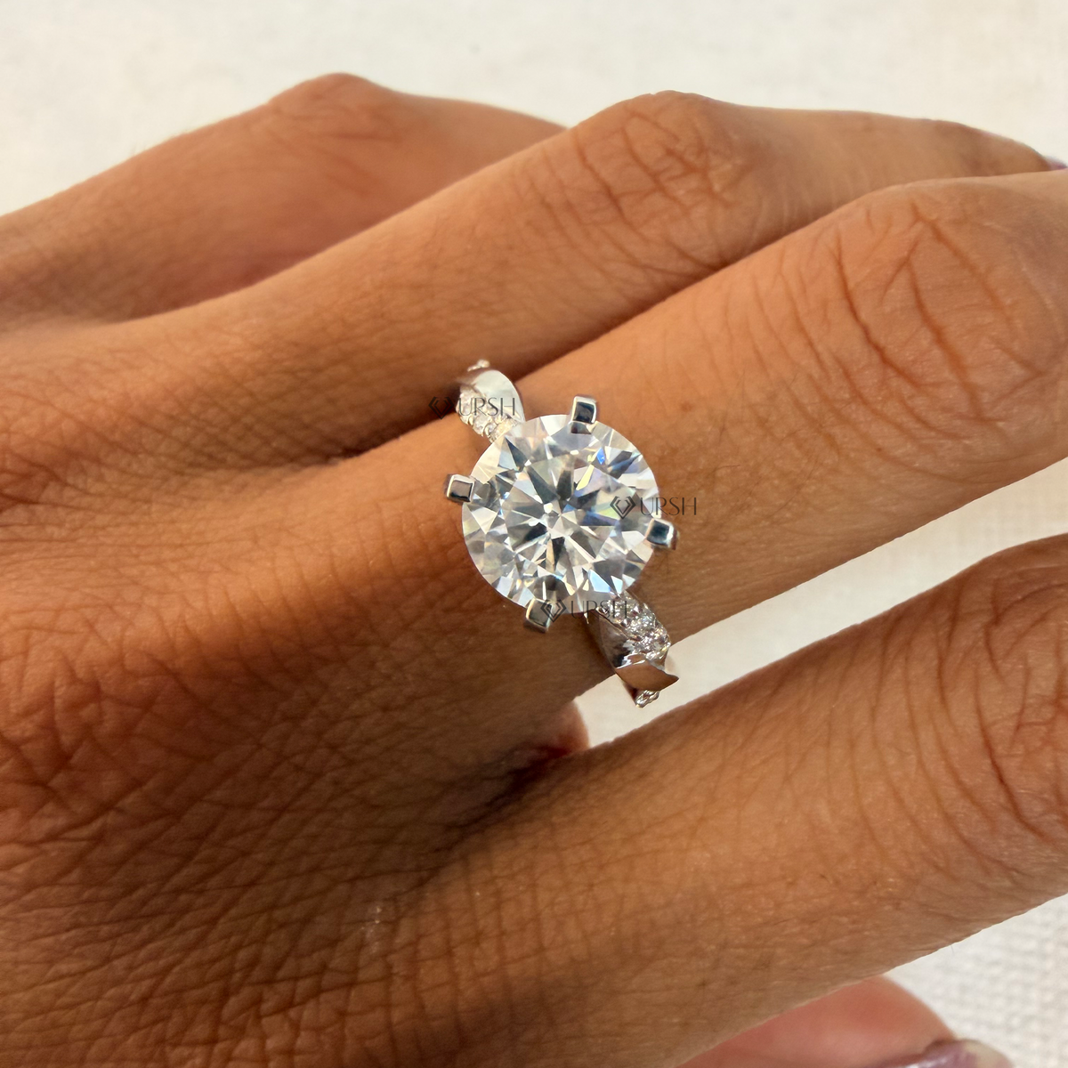 Intertwined twist diamond engagement ring styled gracefully on finger in natural daylight