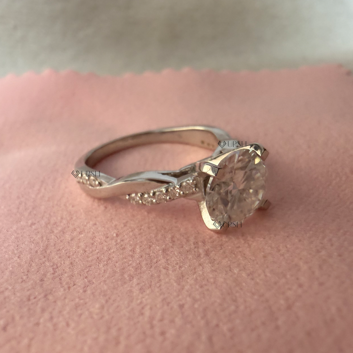 Studio view of white gold twist engagement ring displaying side profile and smooth inner band arch
