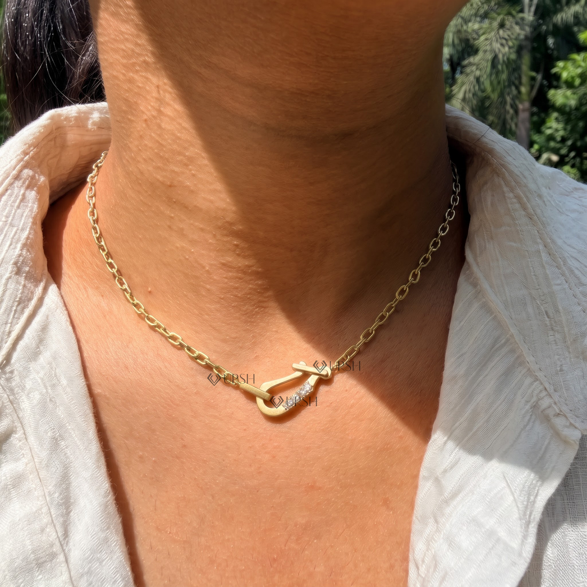 Yellow gold carabiner hook diamond paperclip link necklace styled gracefully on neck in natural daylight