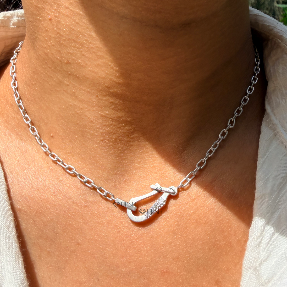 Daylight perspective of white gold carabiner hook diamond paperclip chain worn on neck