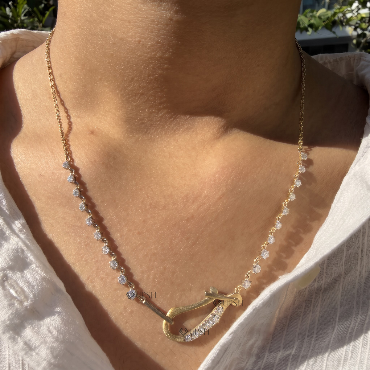 Yellow gold carabiner hook diamond station necklace styled gracefully on neck in natural daylight