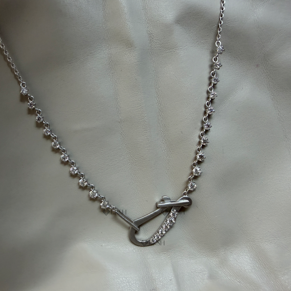 Solid white gold carabiner hook diamond station chain necklace laid flat on presentation background