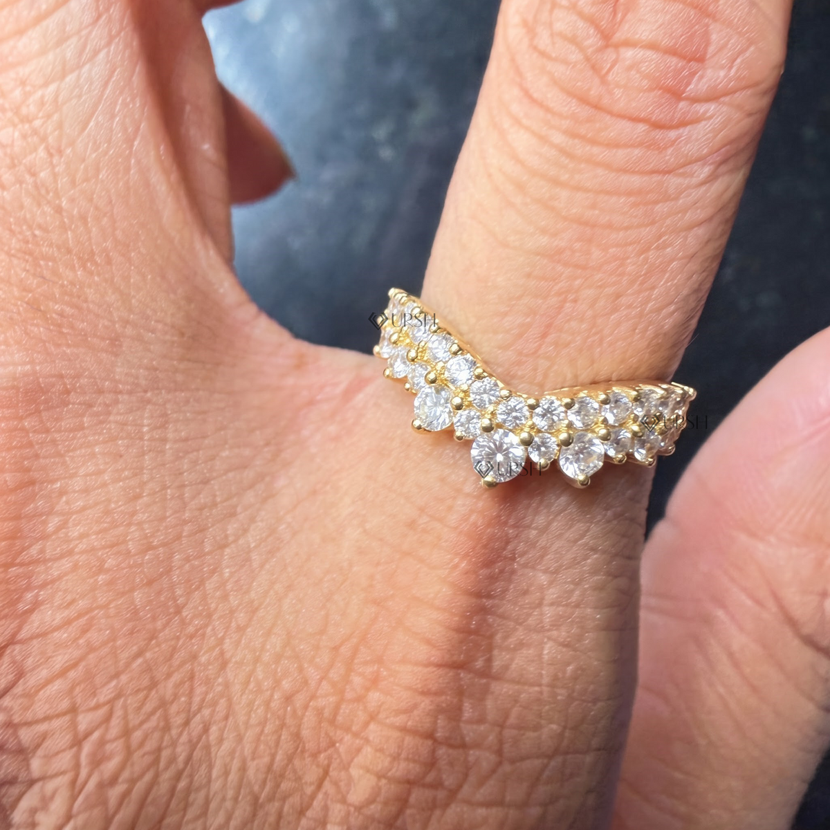 Detailed daylight view of yellow gold chevron crown diamond band worn on finger
