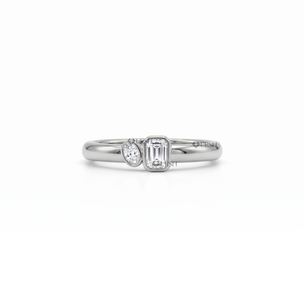 Solid white gold asymmetric toi et moi ring with bezel-set emerald and oval diamonds on a clean white background