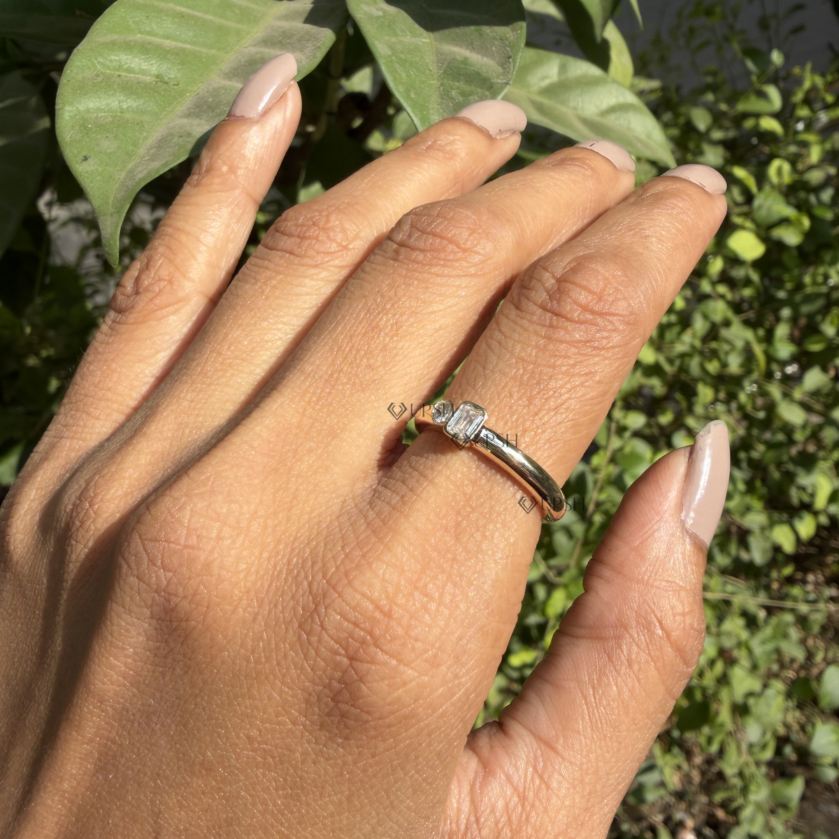 Daylight angle view of two-stone bezel-set diamond ring worn on hand showcasing modern styling