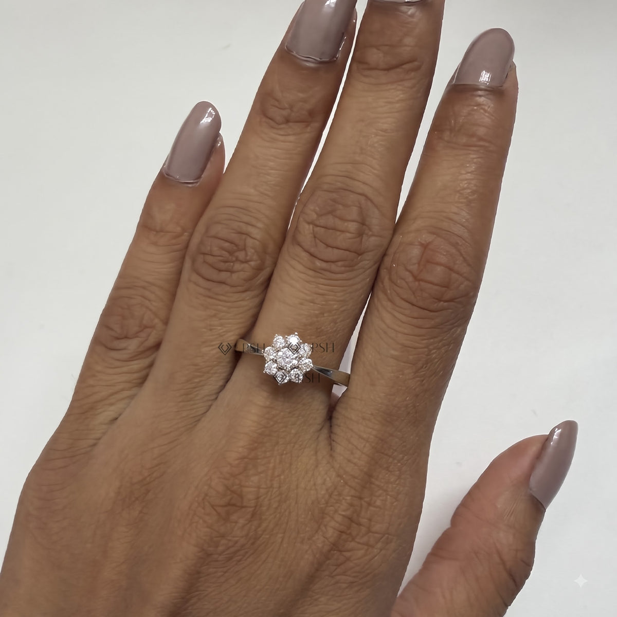 Floral diamond cluster engagement ring styled delicately on ring finger