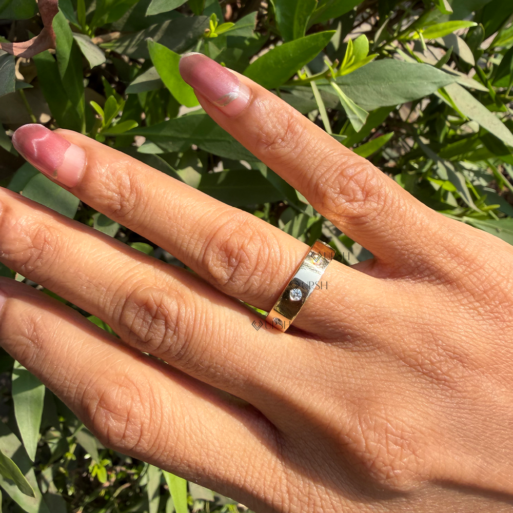 Minimalist wide solid gold gypsy set diamond band catching bright afternoon sun