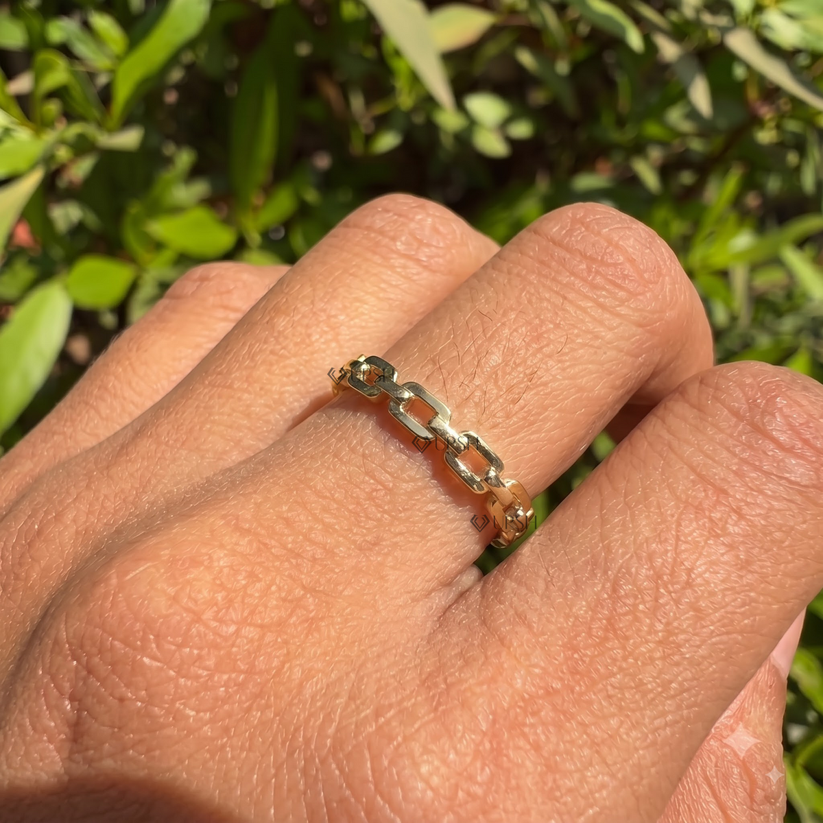 Geometric link chain band styled gracefully on finger in natural daylight