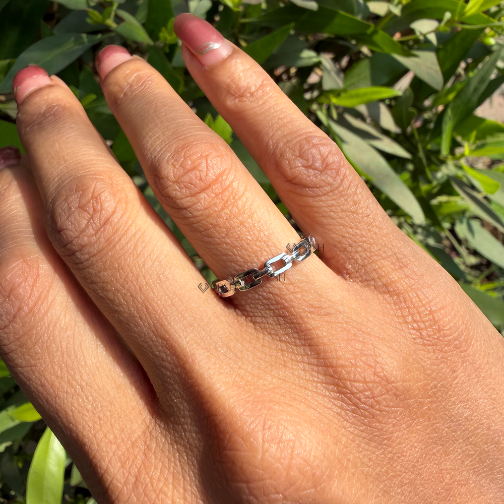 Daylight angle view of white gold geometric link band worn on hand