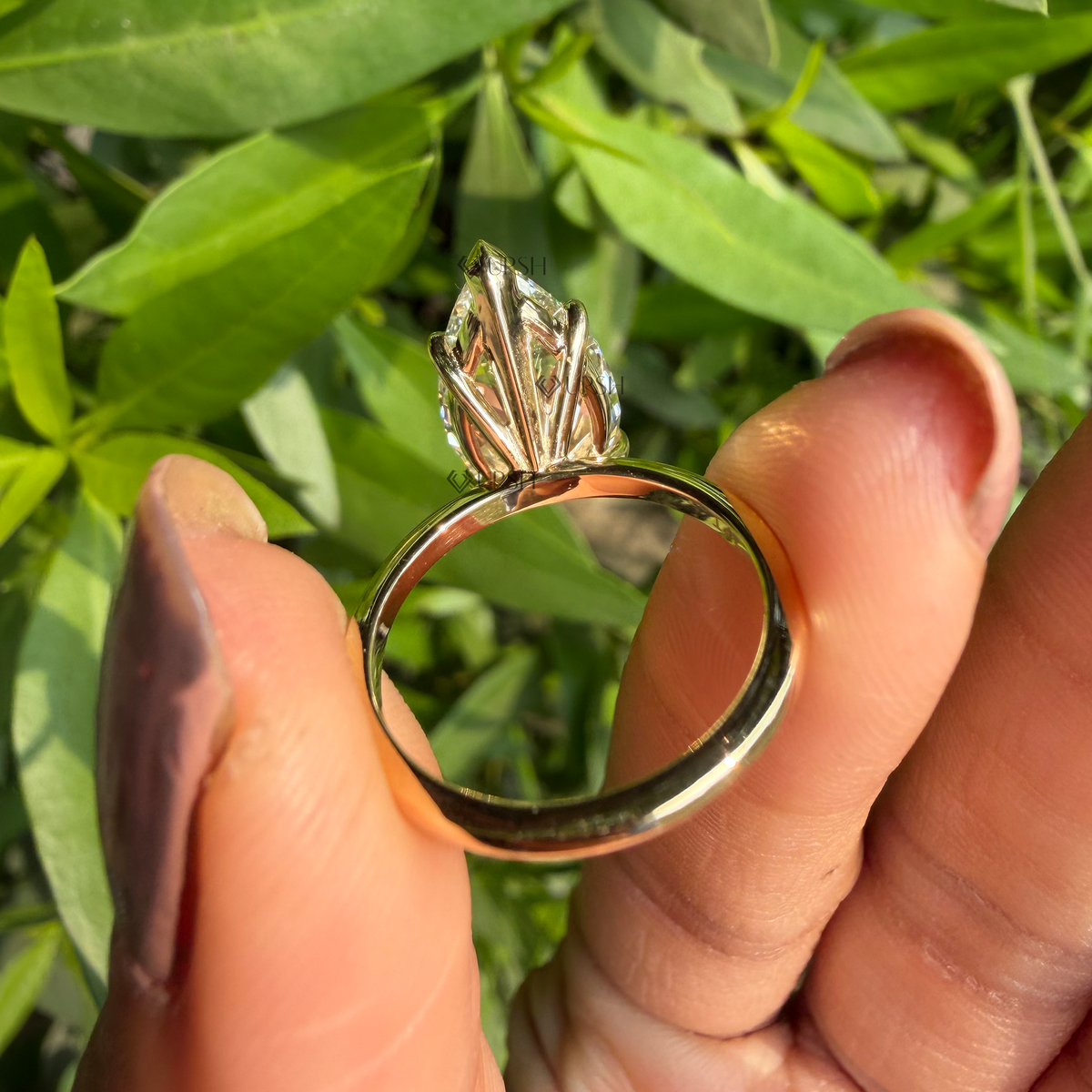 Under-gallery view of pear-cut diamond solitaire ring displaying basket setting and shank underside