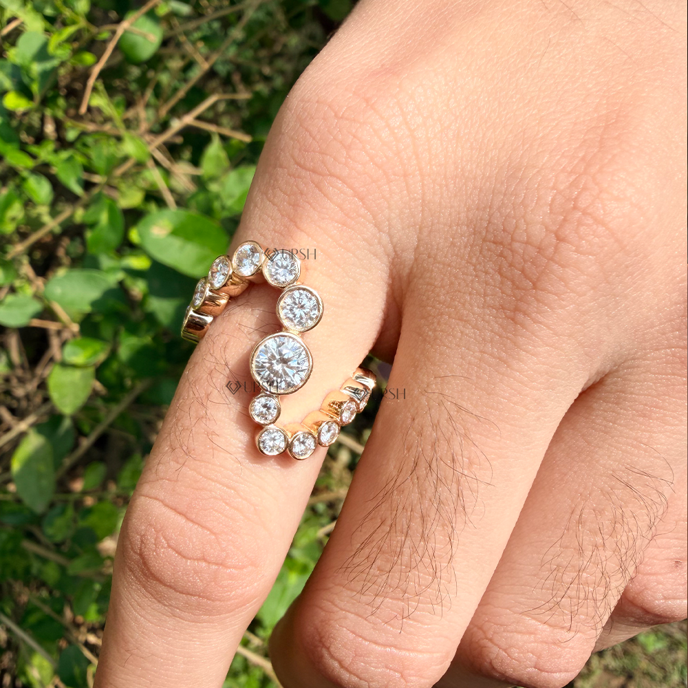 Yellow gold serpentine coiled diamond band catching bright outdoor sunlight on hand