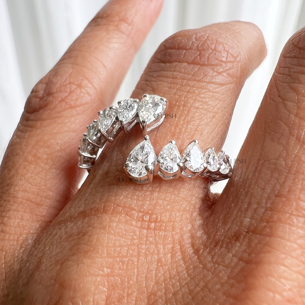 Detailed view of graduated pear cut diamond sparkle and prong alignment on open wrap band