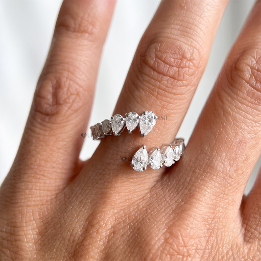 White gold multi-stone pear cut diamond open coil ring worn on manicured hand