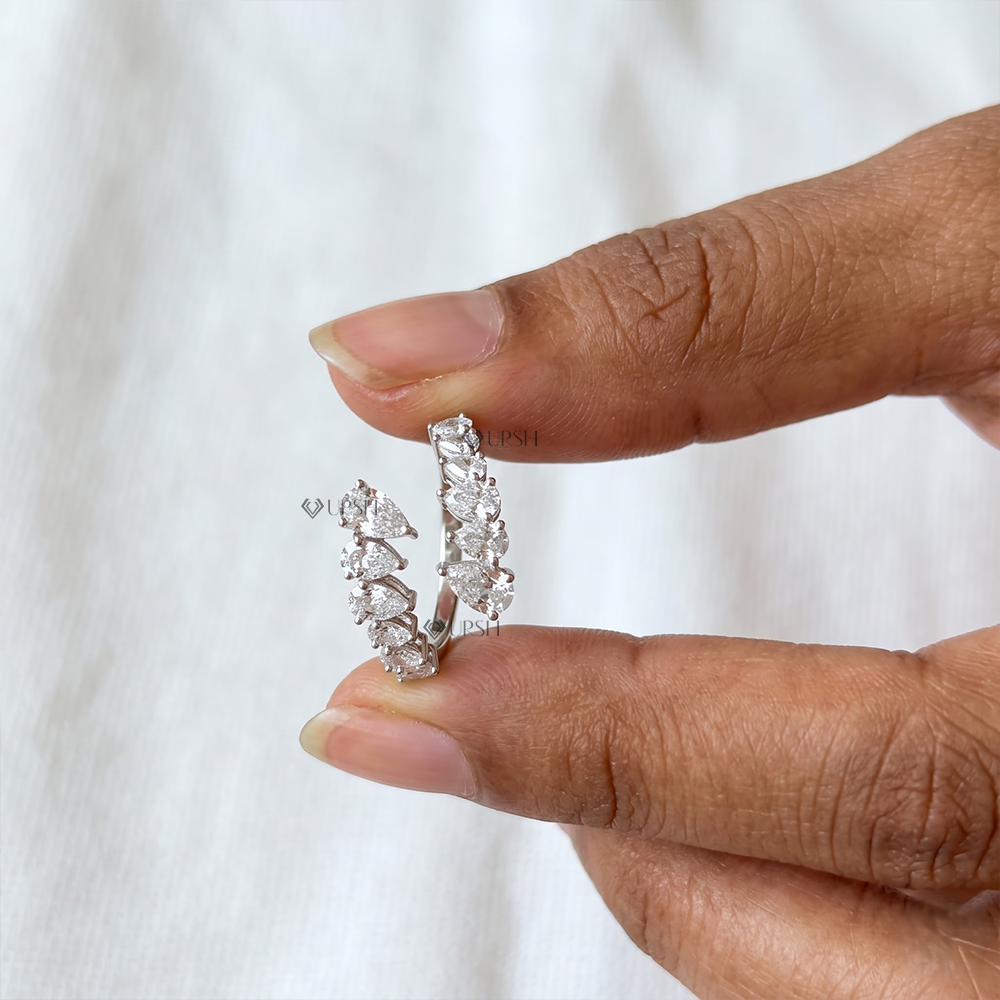Close-up holding white gold pear diamond bypass ring showcasing open coil profile and prong settings