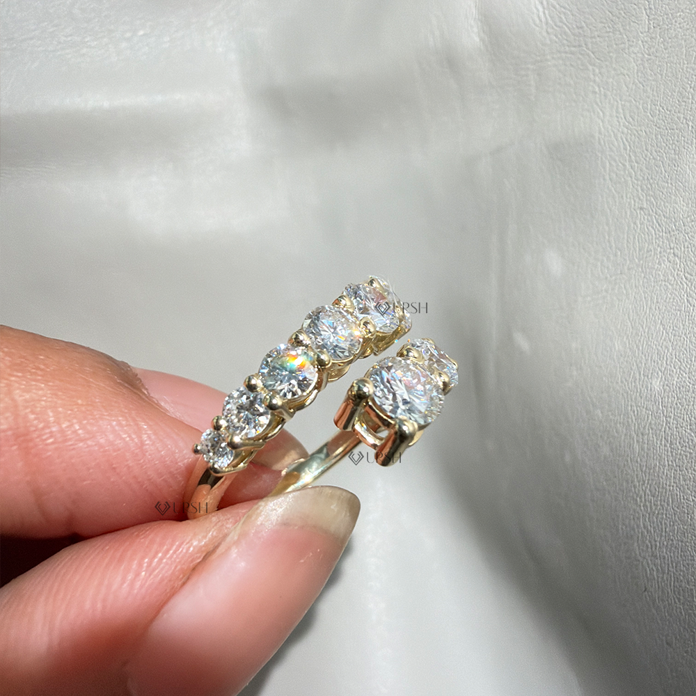 Studio view of prong-set bypass ring highlighting smooth shank and raised stone galleries