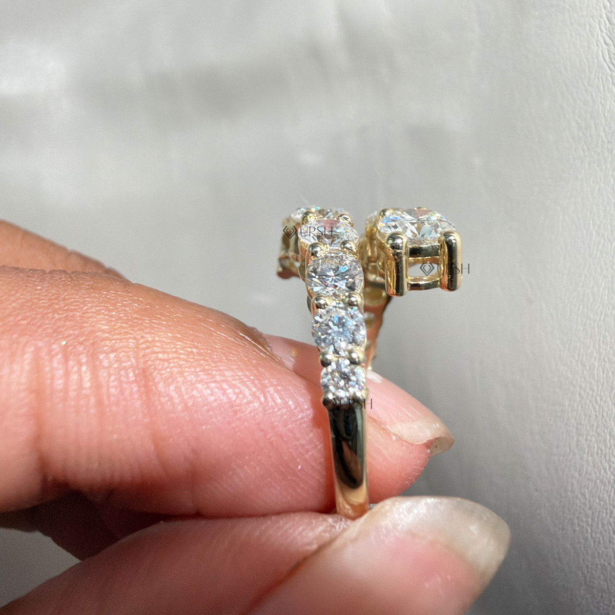 Detailed daylight macro close-up of graduated round lab diamonds in secure prongs worn on hand
