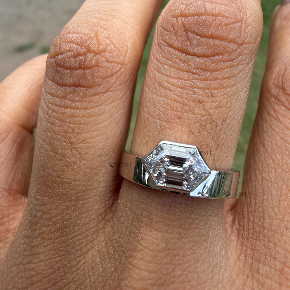 Geometric hexagon diamond bezel solitaire engagement ring worn on finger in natural daylight