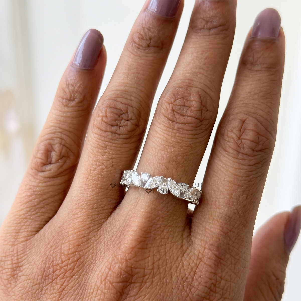 Alternating marquise and round diamond stackable wedding ring worn on hand indoors