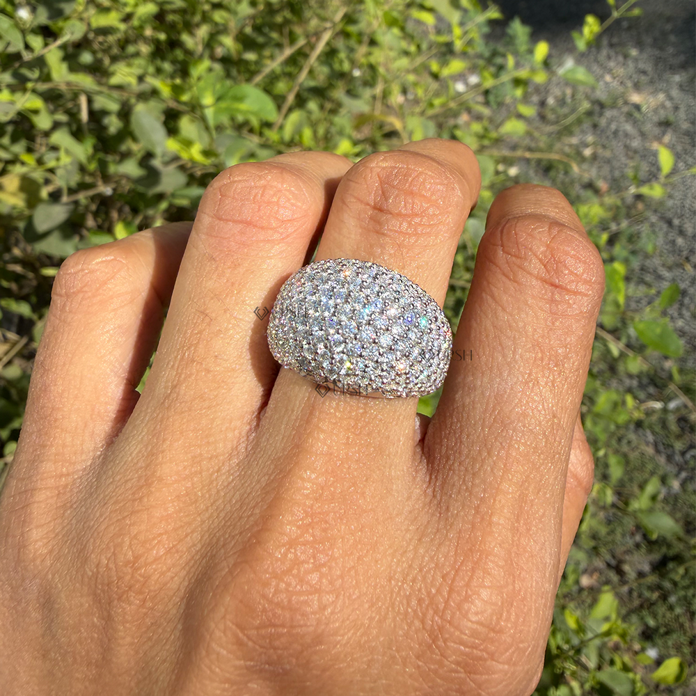 Solid white gold chunky diamond bombé dome statement ring worn on finger in natural sunlight