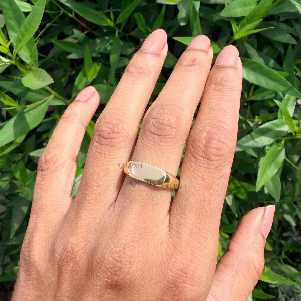 Minimalist oval signet ring styled gracefully on finger in natural daylight