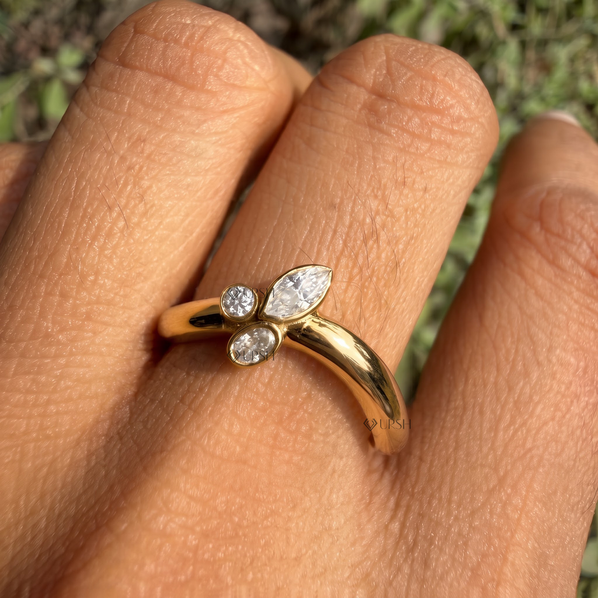 Daylight angle view of yellow gold curved cluster ring worn on hand