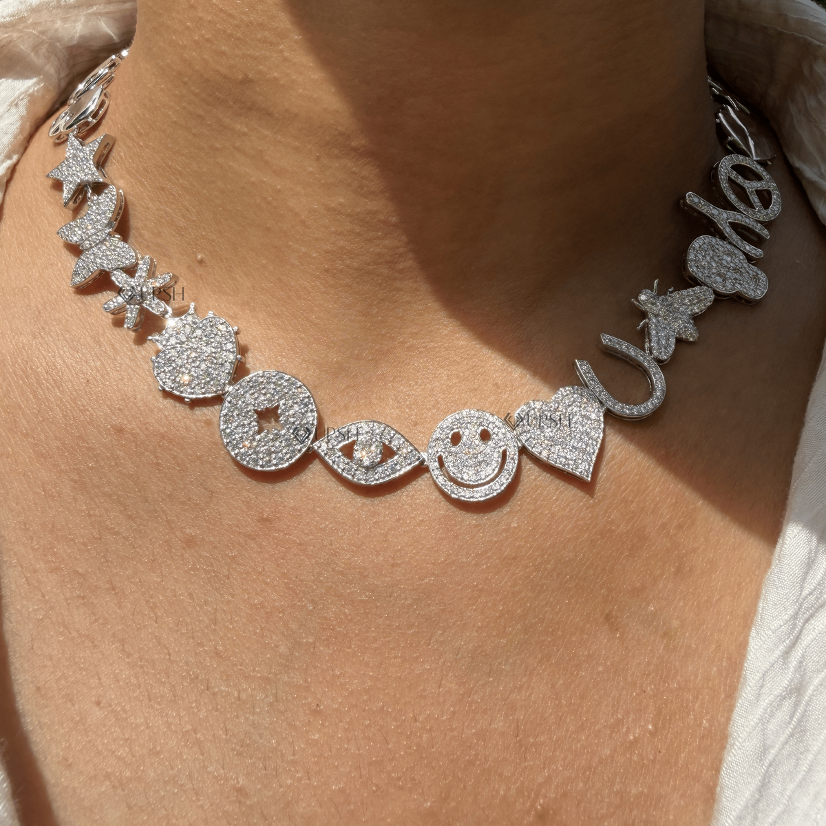 Daylight perspective view of white gold multi-charm diamond station necklace worn on neck