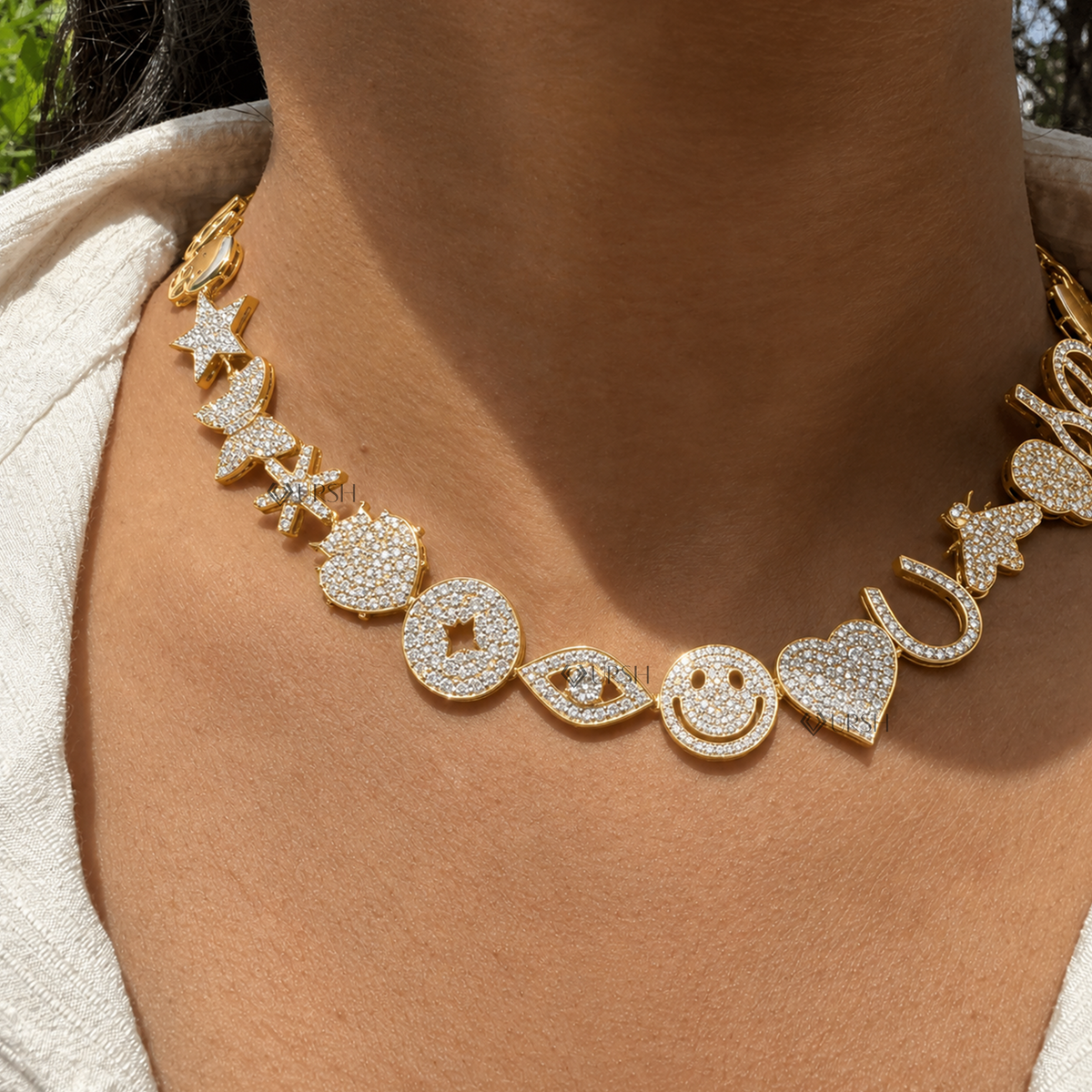 Daylight angle view of yellow gold eclectic charm station diamond necklace worn along collarbone