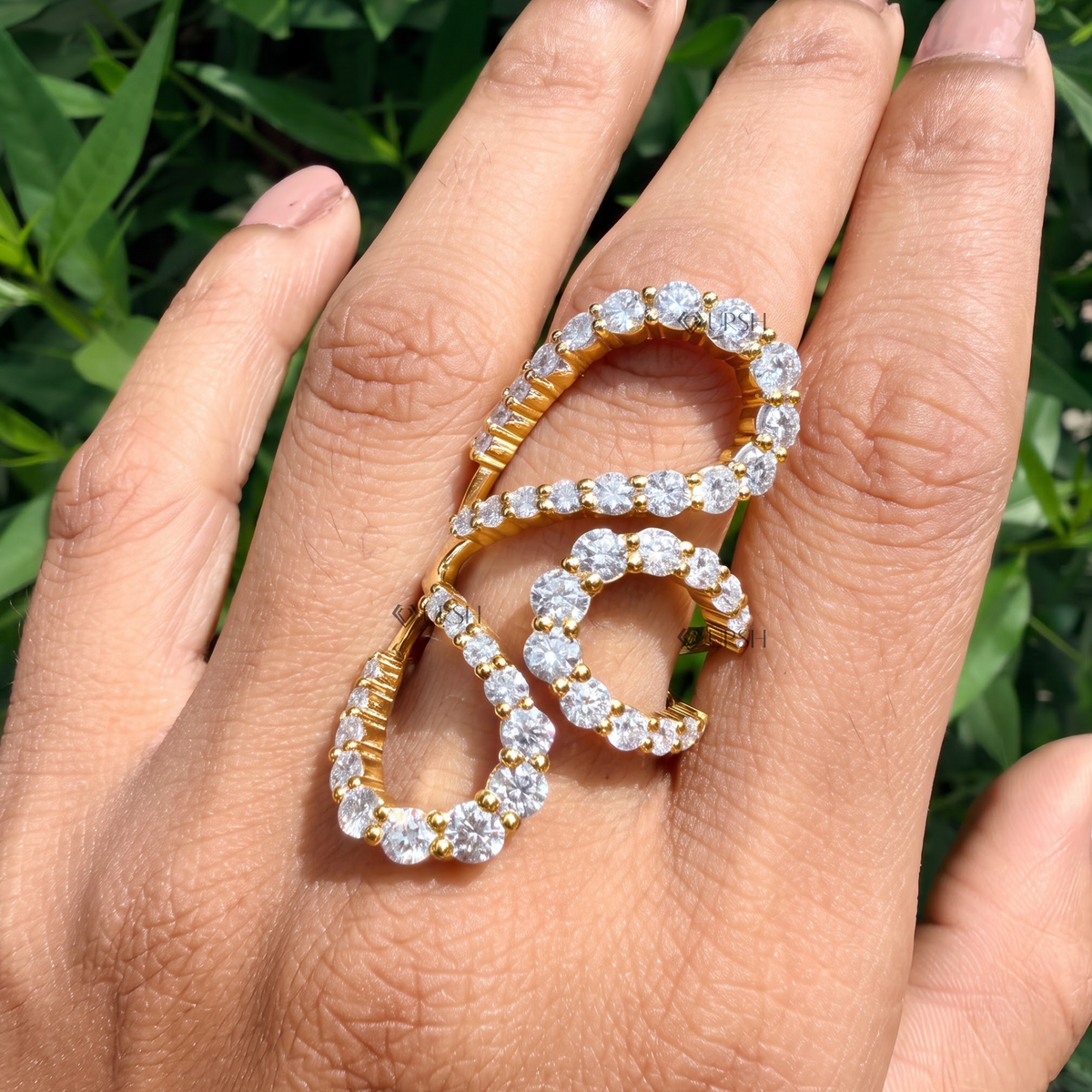 Avant-garde multi-finger statement ring styled gracefully across hand in natural daylight