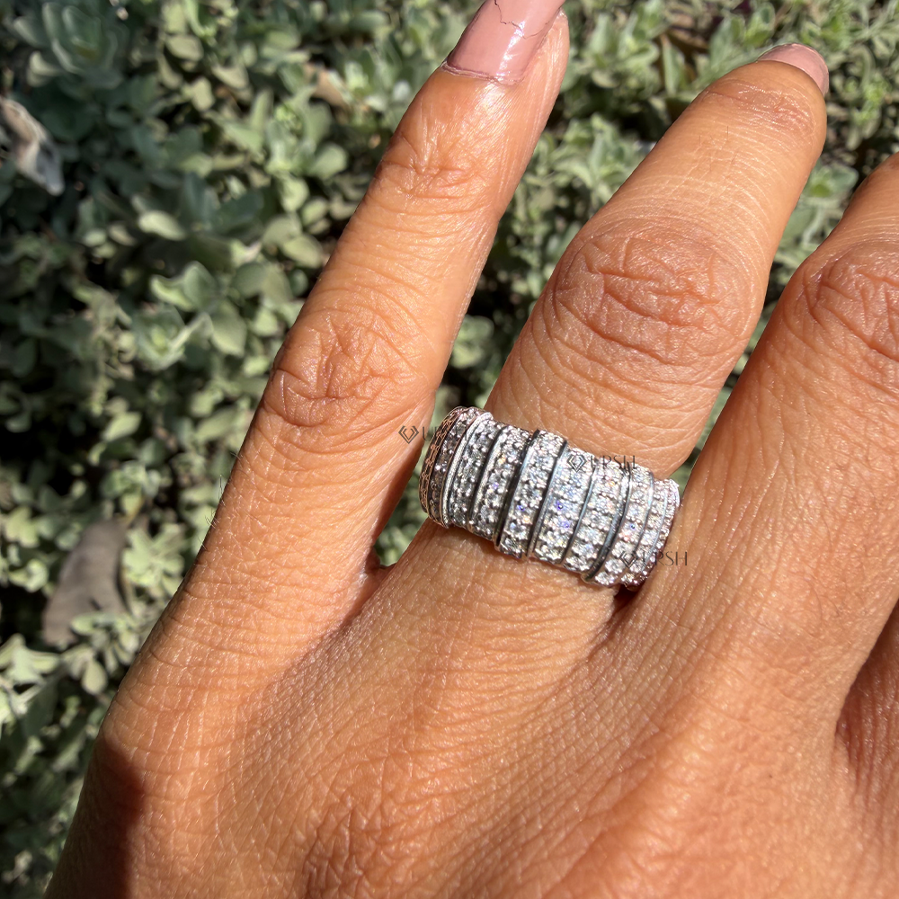 White gold wide pavé barrel ring worn against natural garden greenery