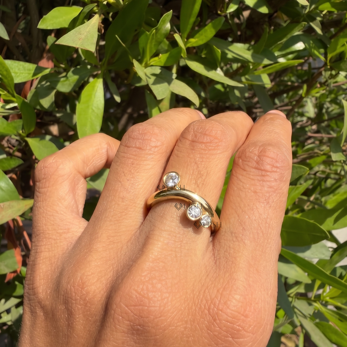 Bezel-set multi-stone round diamond curved ring styled gracefully on finger in natural daylight
