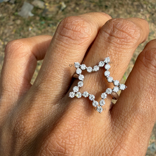 Large diamond open star knuckle ring styled on ring finger in natural outdoor daylight