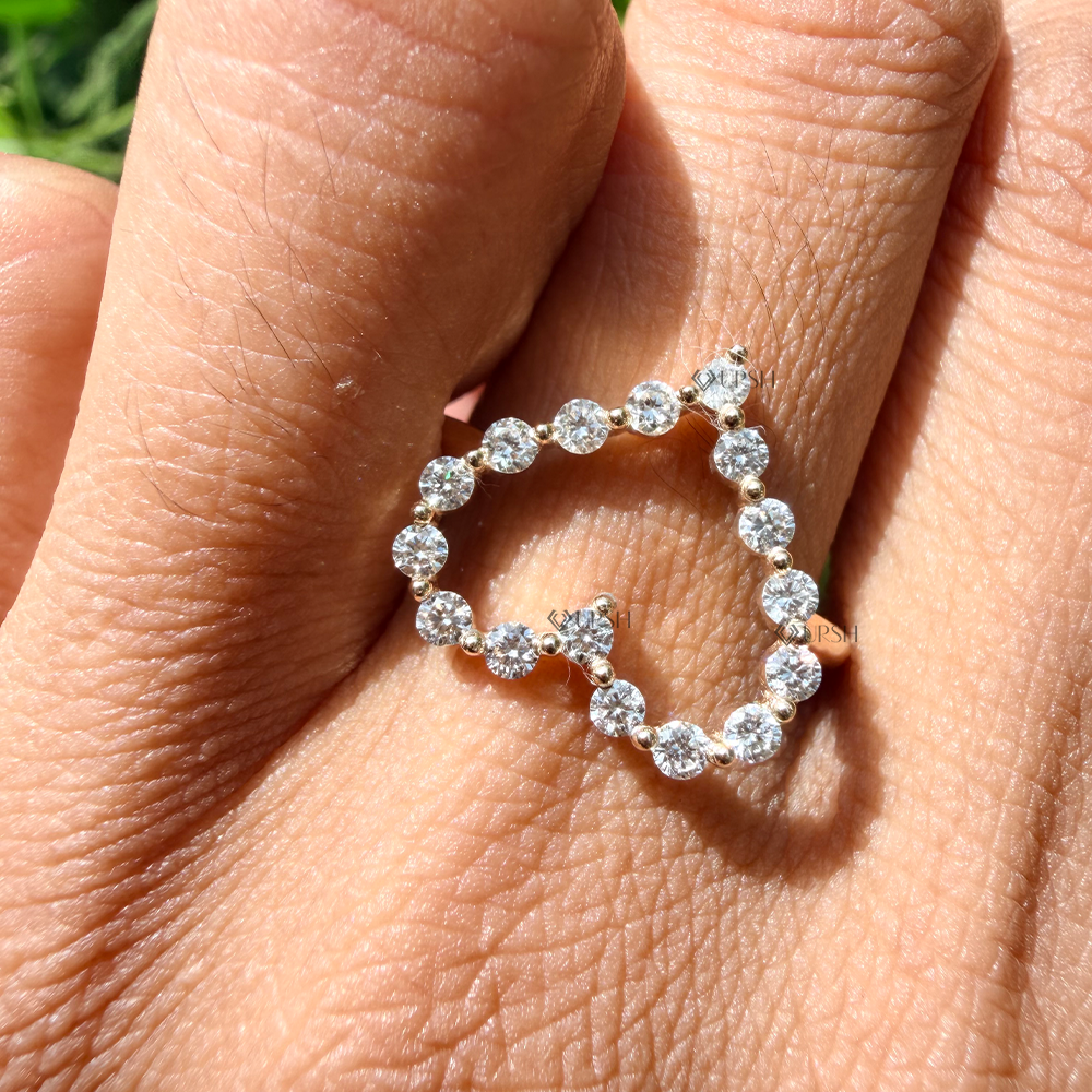 Open heart diamond knuckle ring worn on index finger in natural daylight