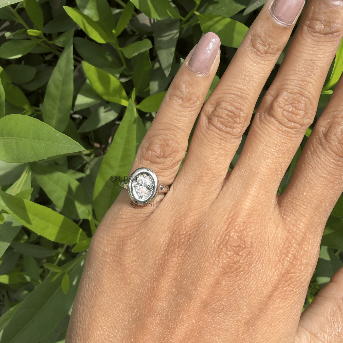 Close-up daylight angle view of oval statement ring worn on finger displaying smooth shank and bezel edge
